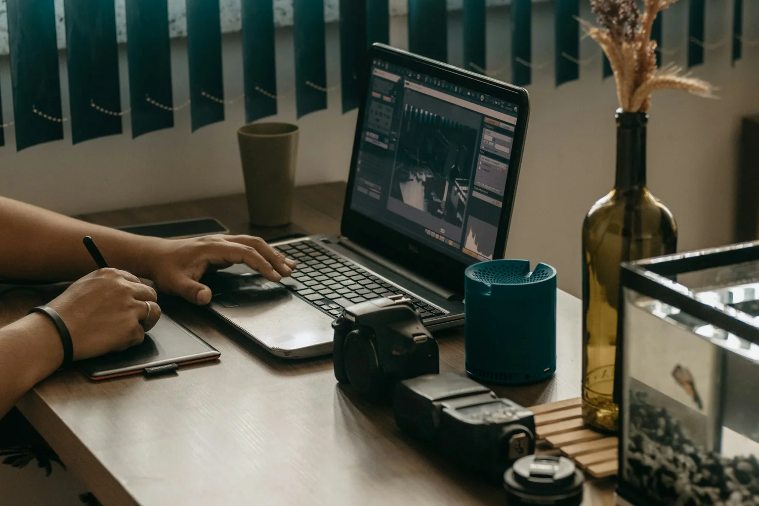 Photographer planning work at a laptop with camera equipment nearby