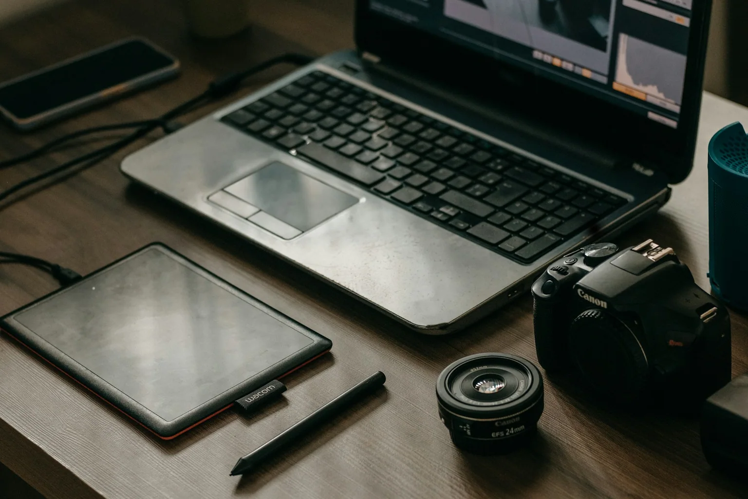 Photographer editing workspace with laptop, camera, and tablet